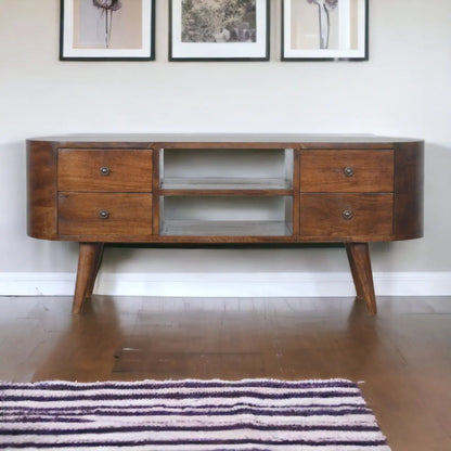Wooden console table with drawers and a central shelf against a white wall.