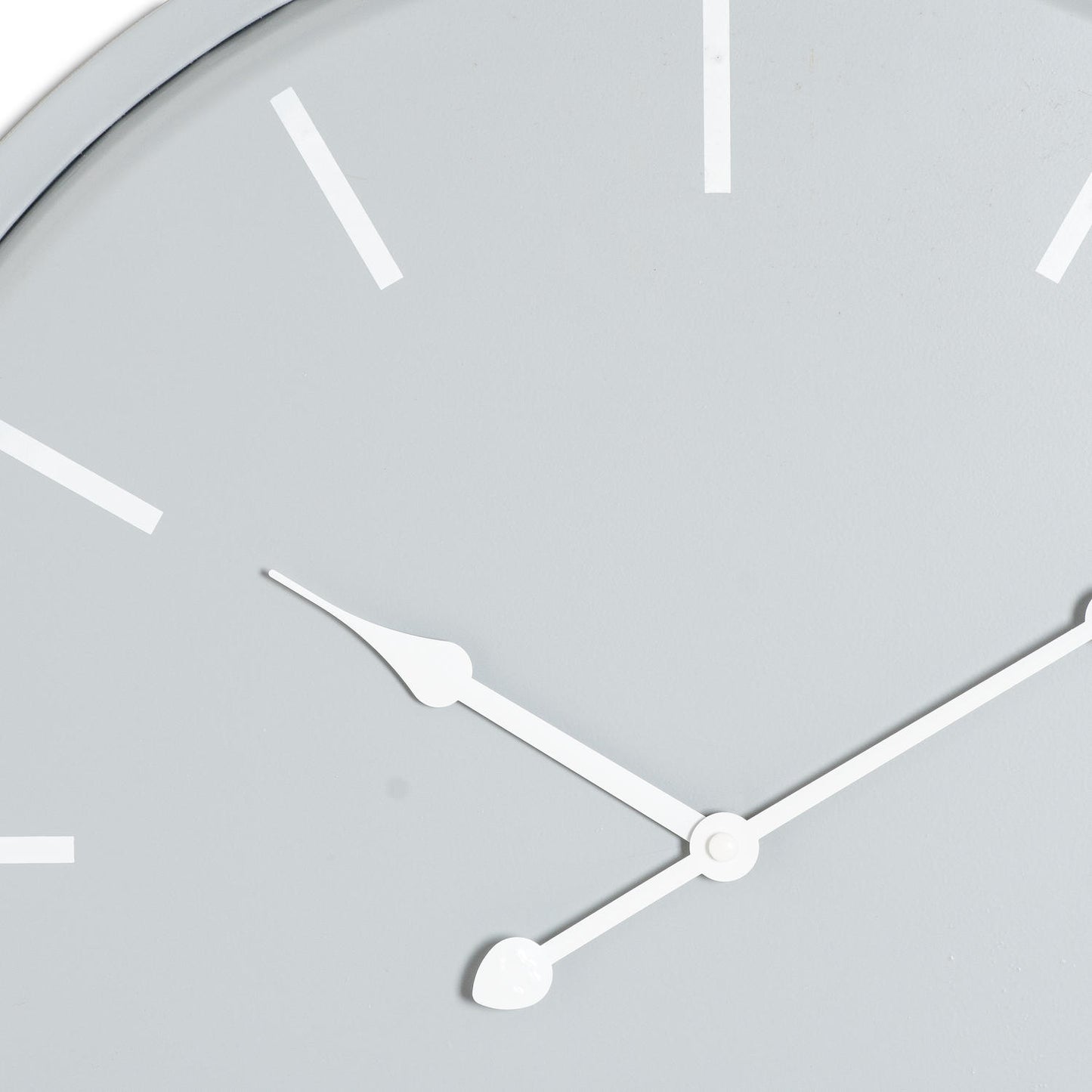 Close-up of a clock face with white hands on a light gray background