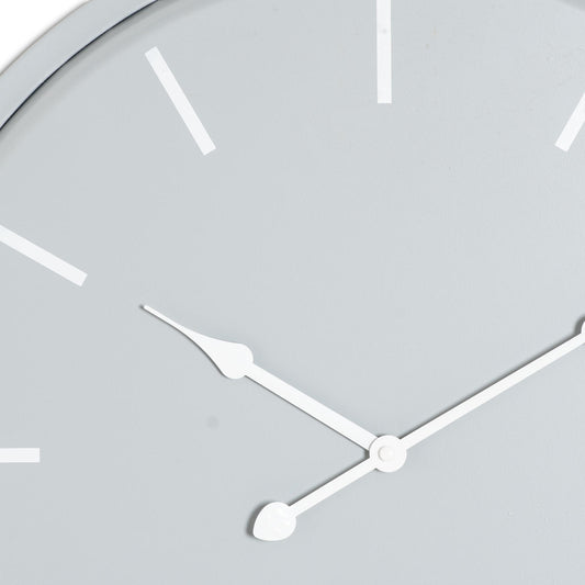 Close-up of a clock face with white hands on a light gray background