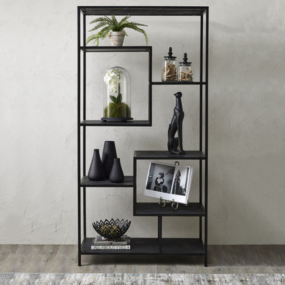 Black metal shelf with decorative items against a plain wall