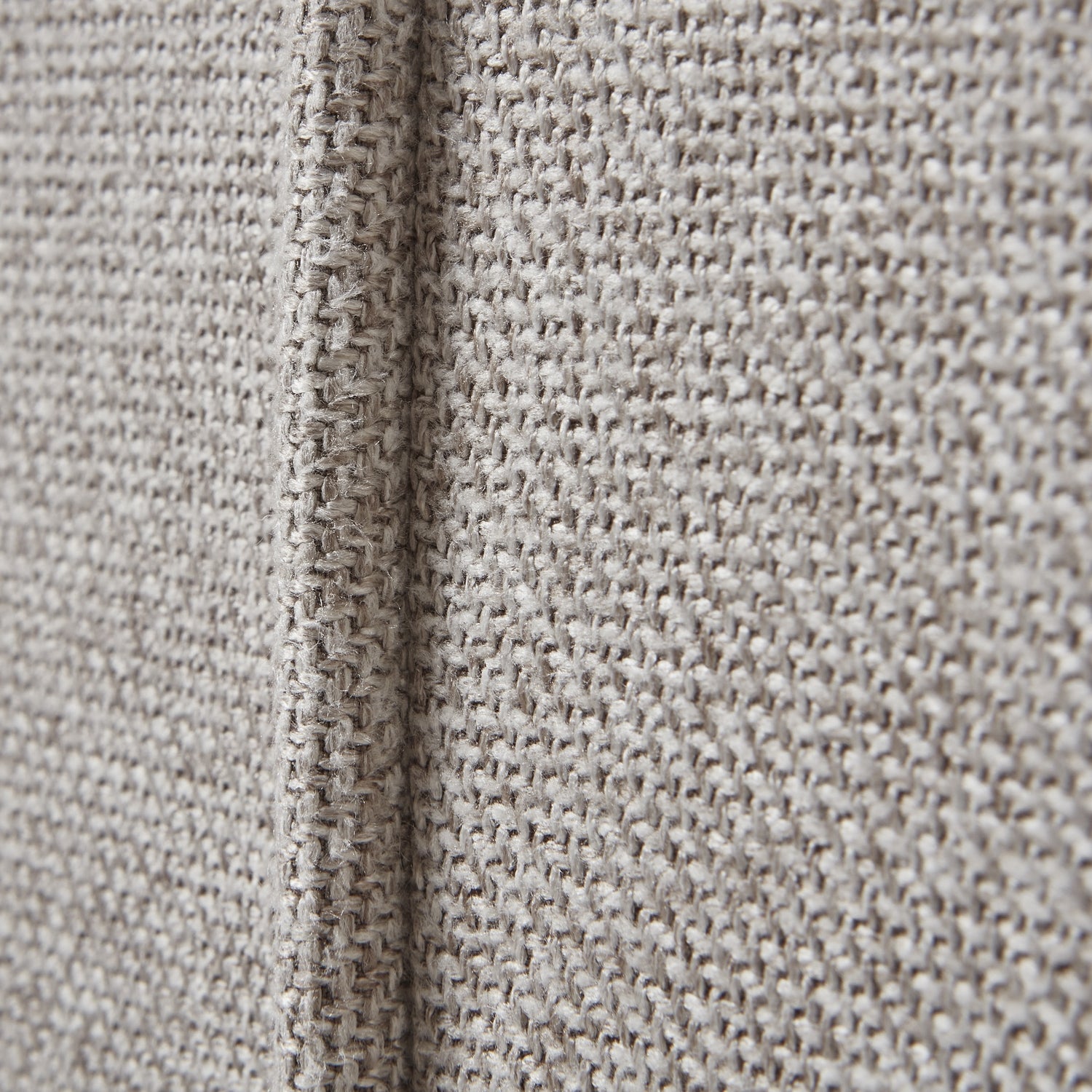 Close-up of textured beige fabric with a visible seam.