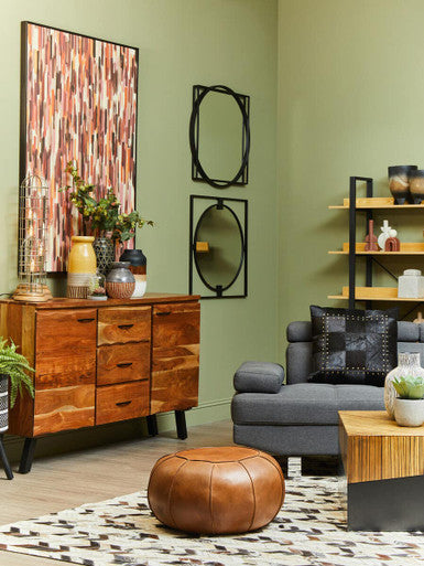 Living room with wooden sideboard, gray sofa, and brown ottoman.