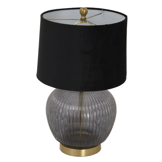 Table lamp with black shade, ribbed glass base, and gold accents on a white background