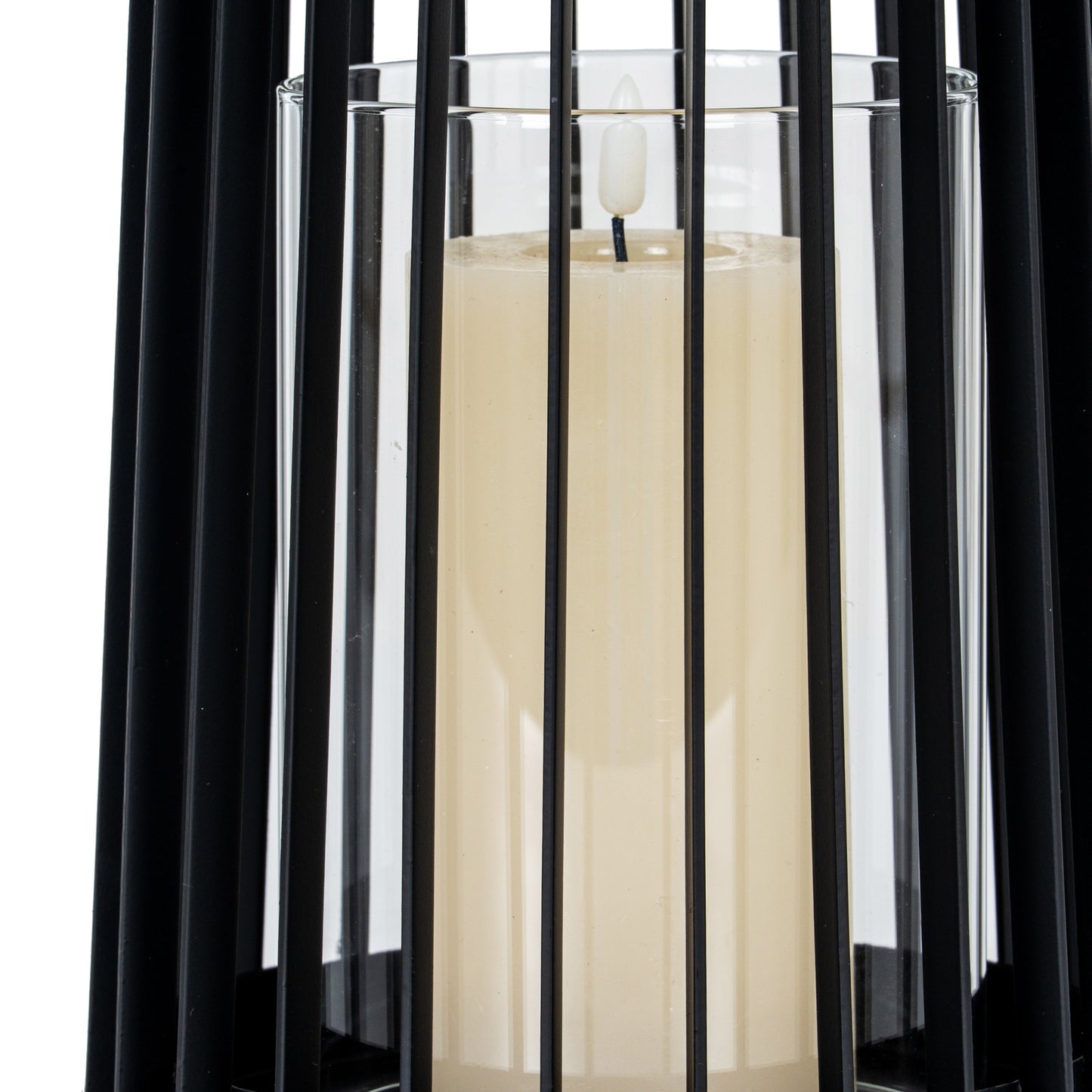 White candle in a glass holder with black metal bars on a white background