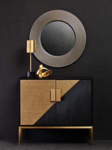 Modern cabinet with geometric design against a black wall with a round mirror.