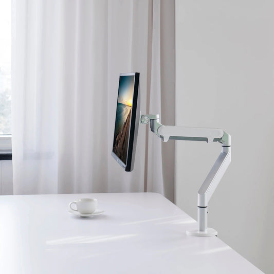 Monitor on a white desk with a white curtain in the background