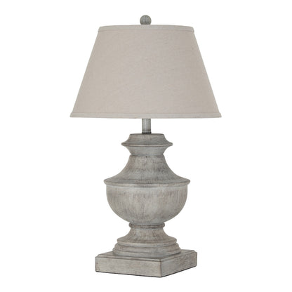 Table lamp with a textured base and beige shade on a white background