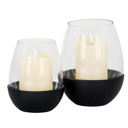 Two candle holders with candles inside on a white background