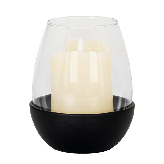 Candle in a clear glass holder with black base on a white background
