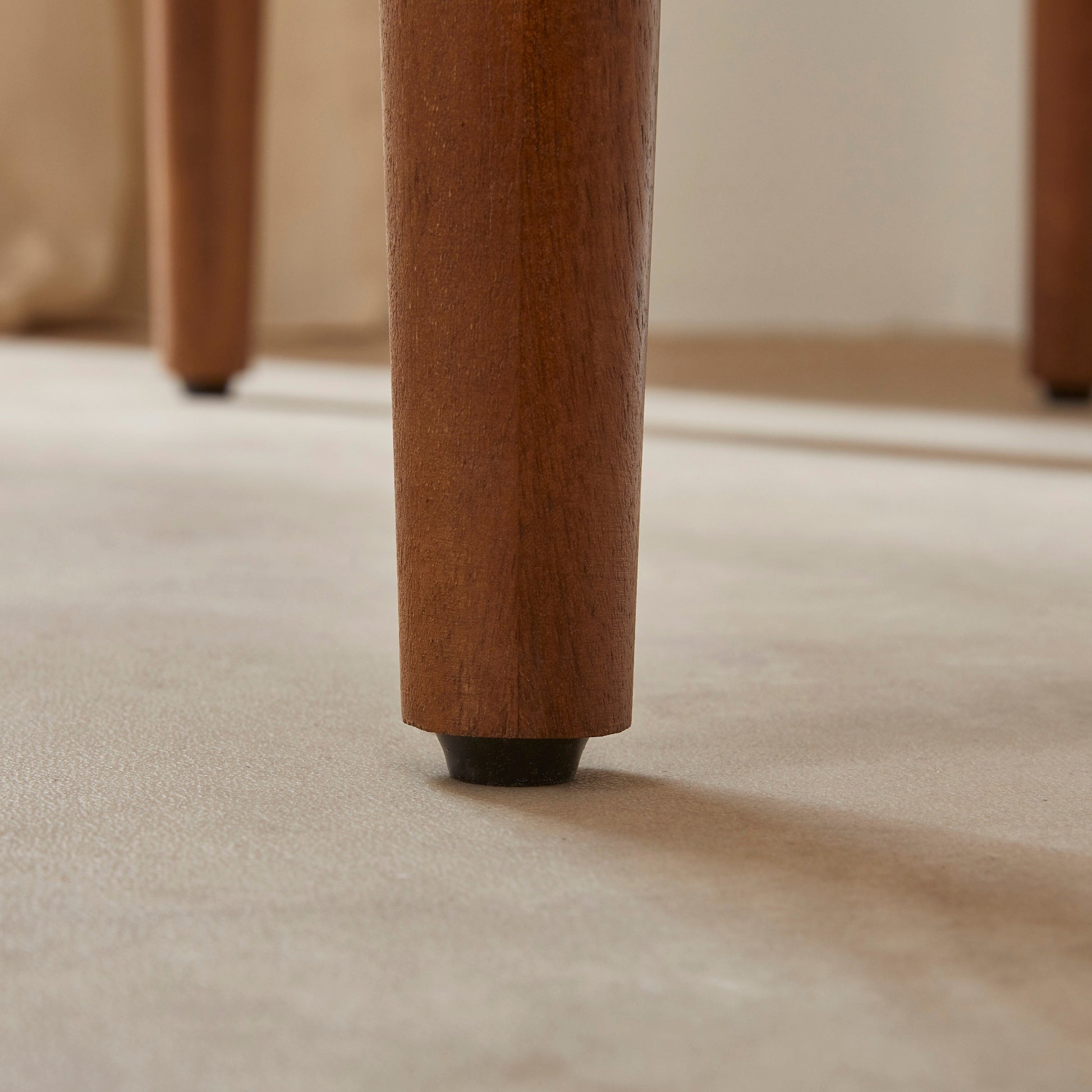 Close-up of a wooden leg on a carpeted floor