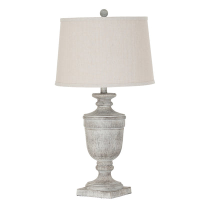 Table lamp with a textured gray base and a white lampshade on a white background