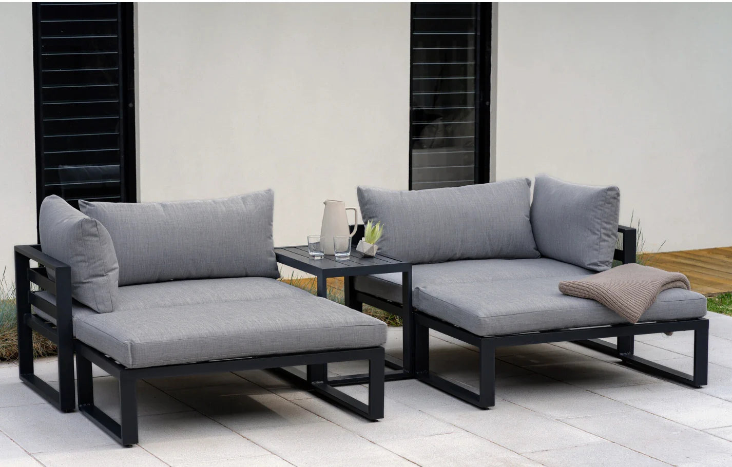 Outdoor patio furniture set with gray cushions on a wooden deck.