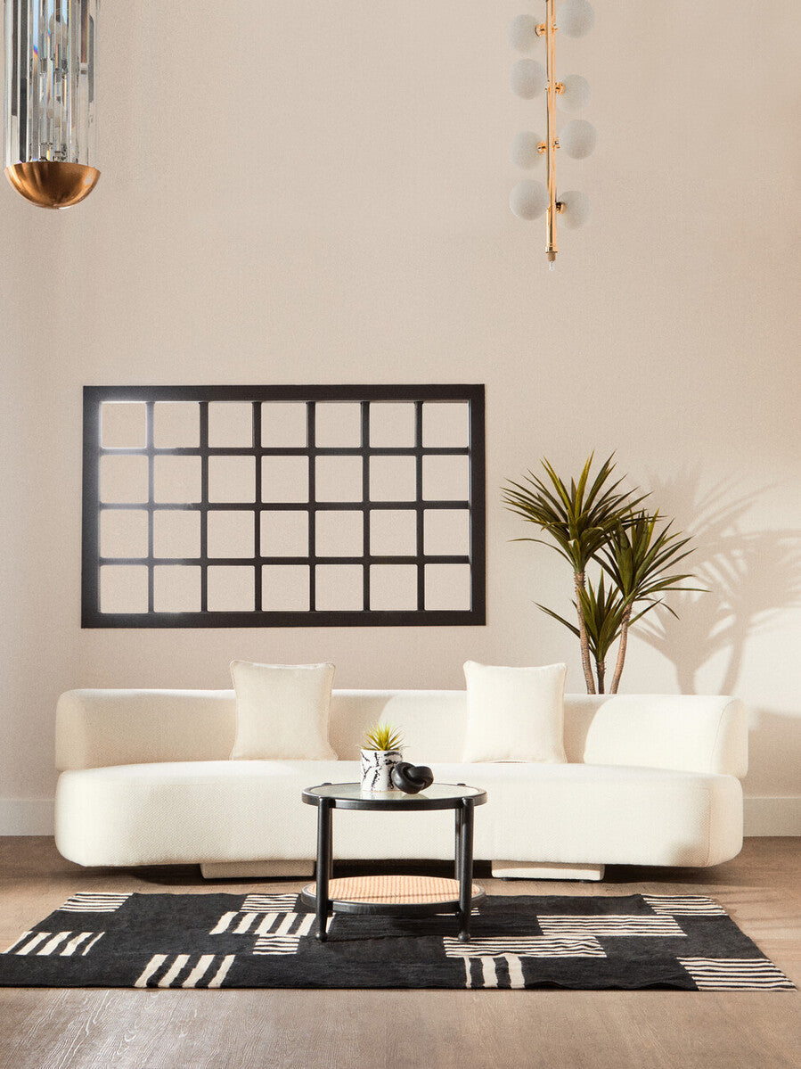 Modern living room with a white sofa, coffee table, and decorative elements.