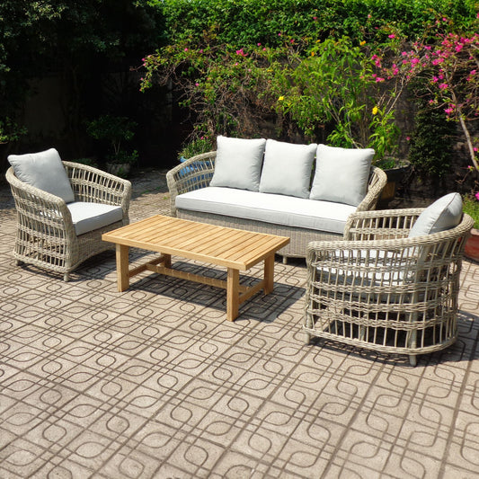 Outdoor patio set with wicker chairs, sofa, and table on a patterned patio.