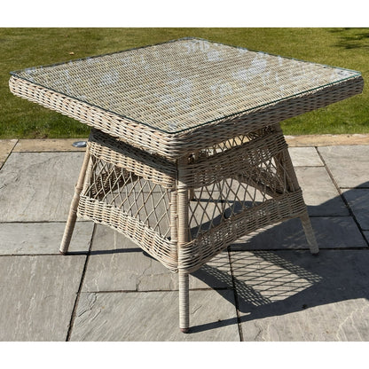Wicker outdoor table on a patio with grass in the background