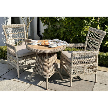 Wicker outdoor furniture set with a small table and two chairs on a patio.
