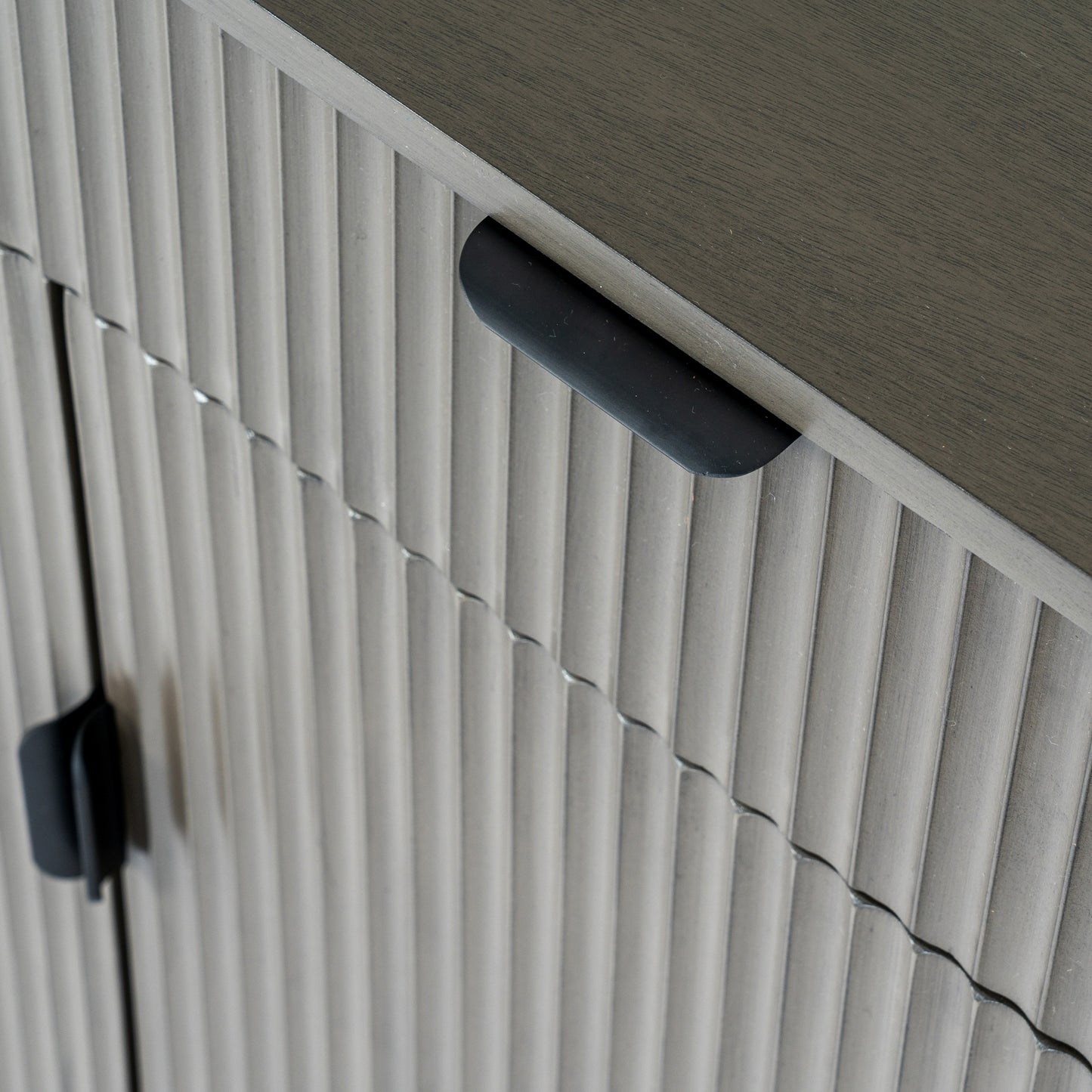 Close-up of a textured wall with horizontal slats and a black handle.