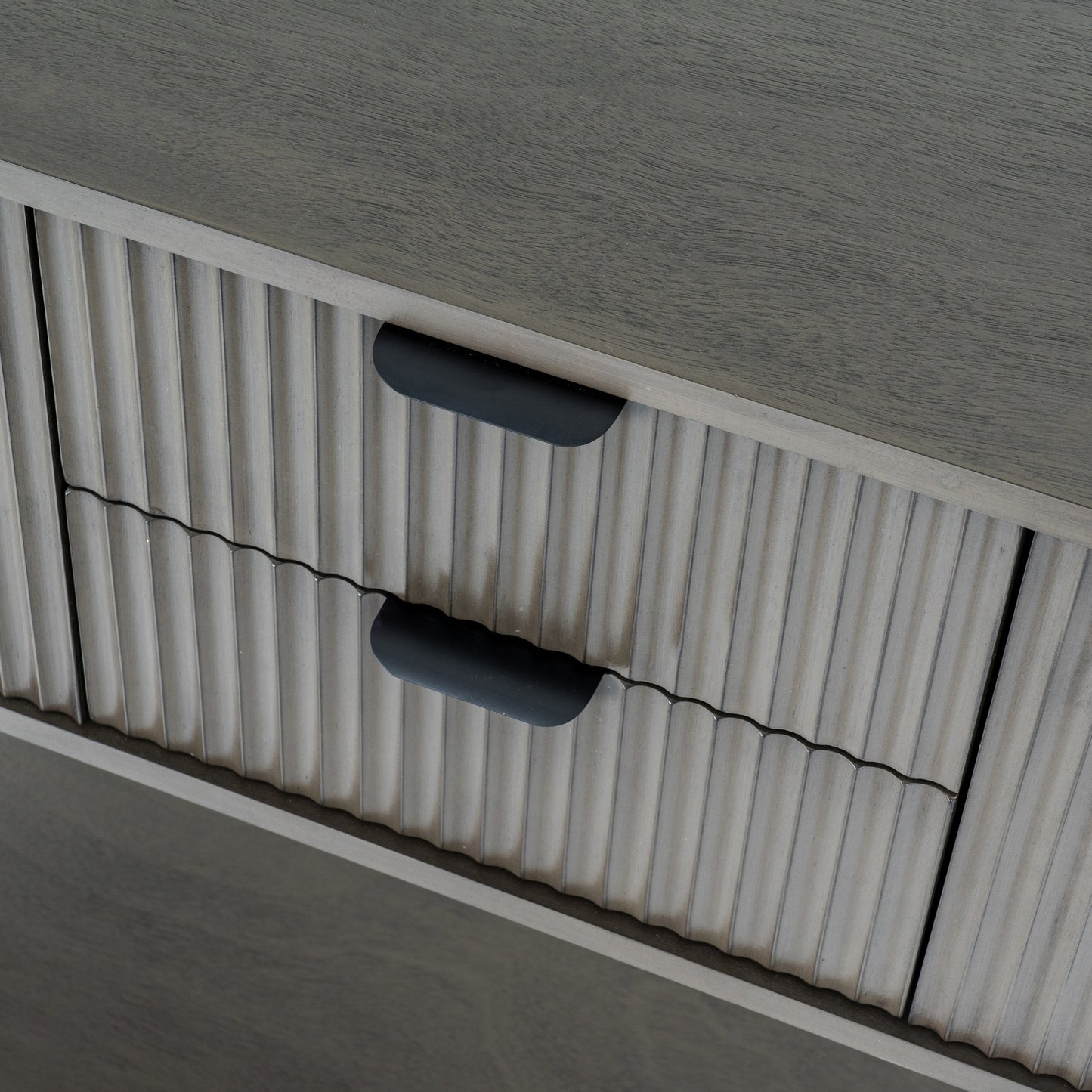 Close-up of a textured surface with ribbed pattern and black handles.