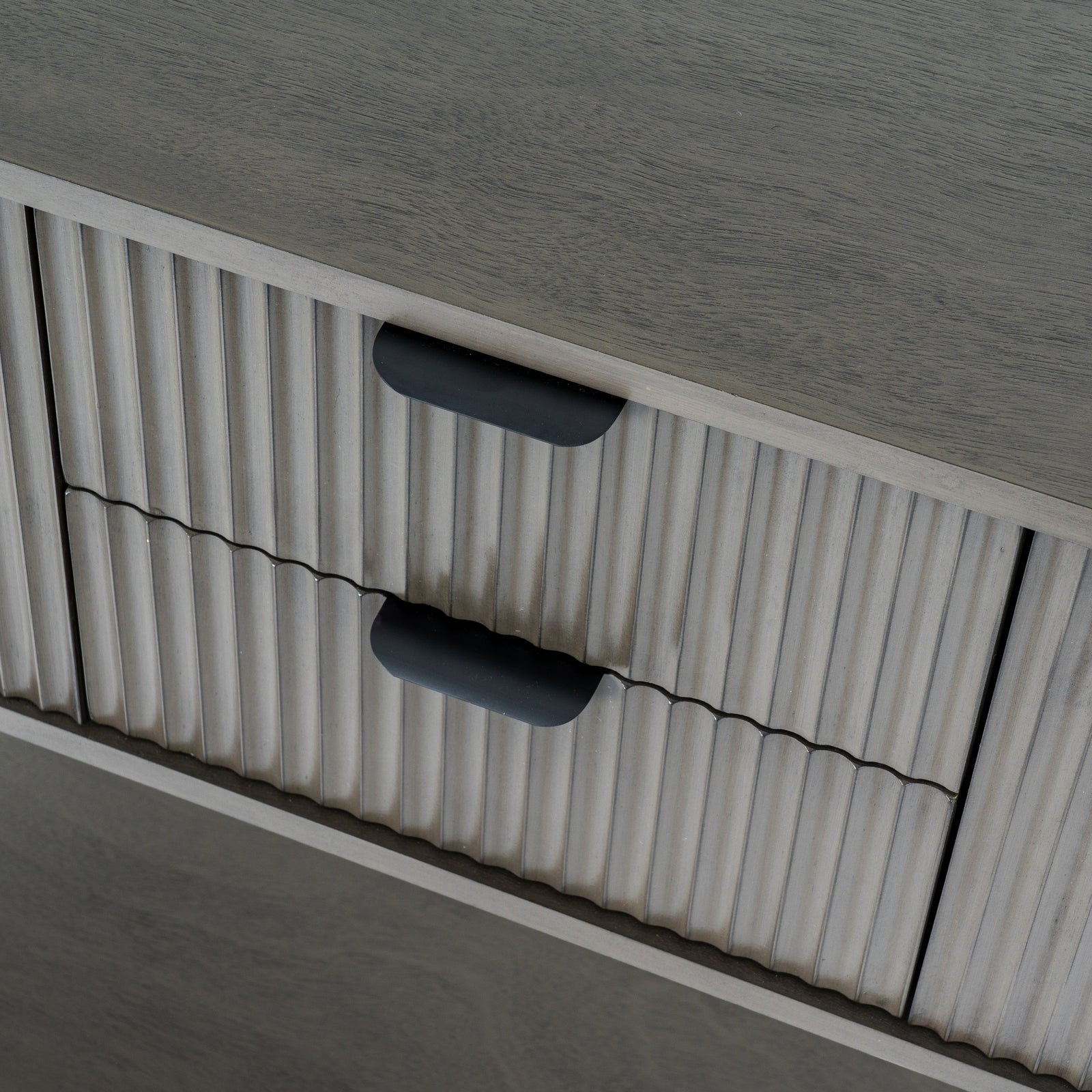 Close-up of a textured surface with ribbed pattern and black handles.