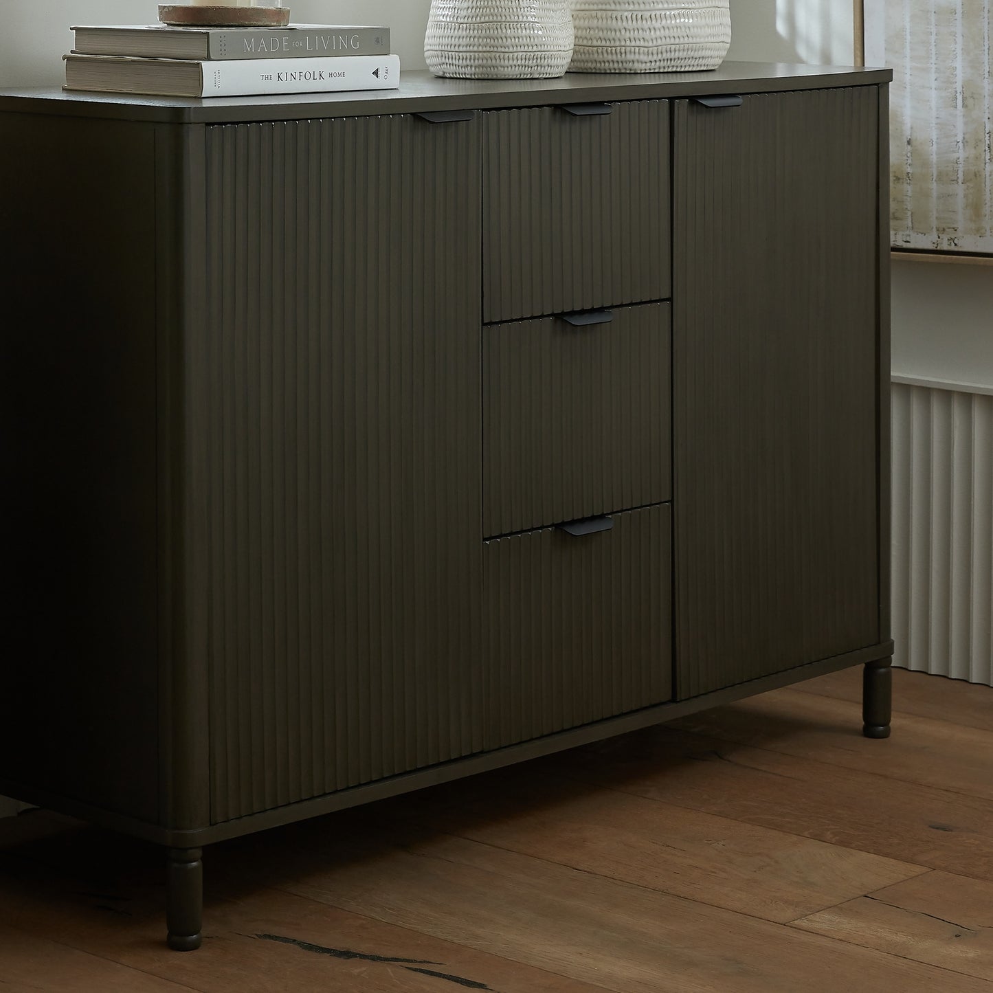 Dark wooden sideboard with drawers on a wooden floor