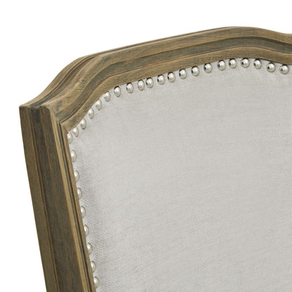 Close-up of a wooden headboard with decorative nailhead trim on a white background