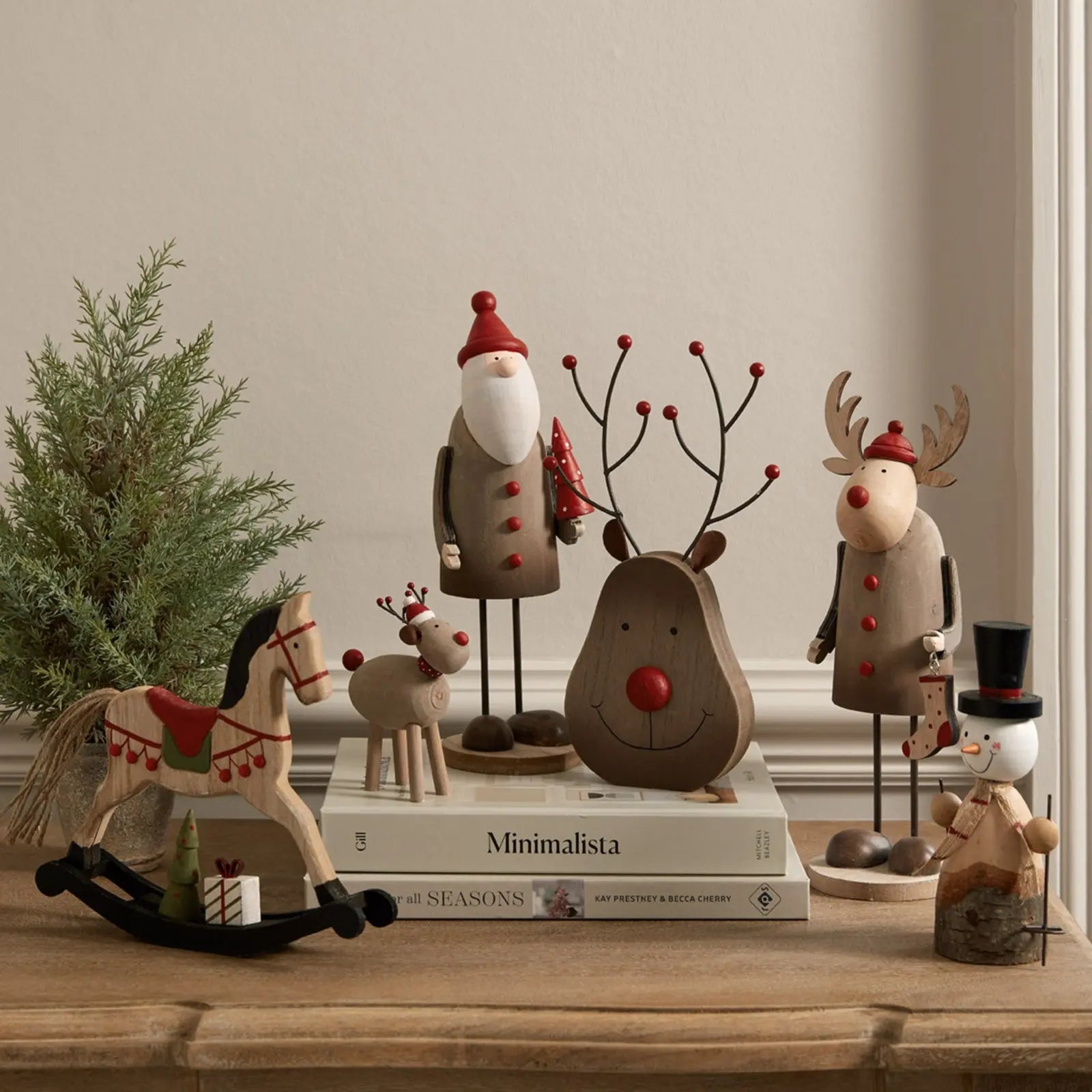 Wooden Christmas decorations including a reindeer, Santa Claus, and other festive figures on a table.
