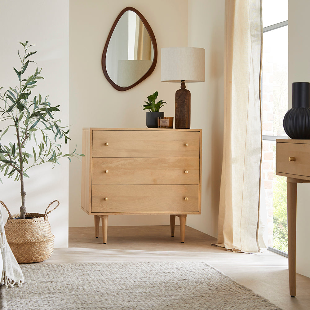 Wooden dresser with decorative items in a bright room with natural light