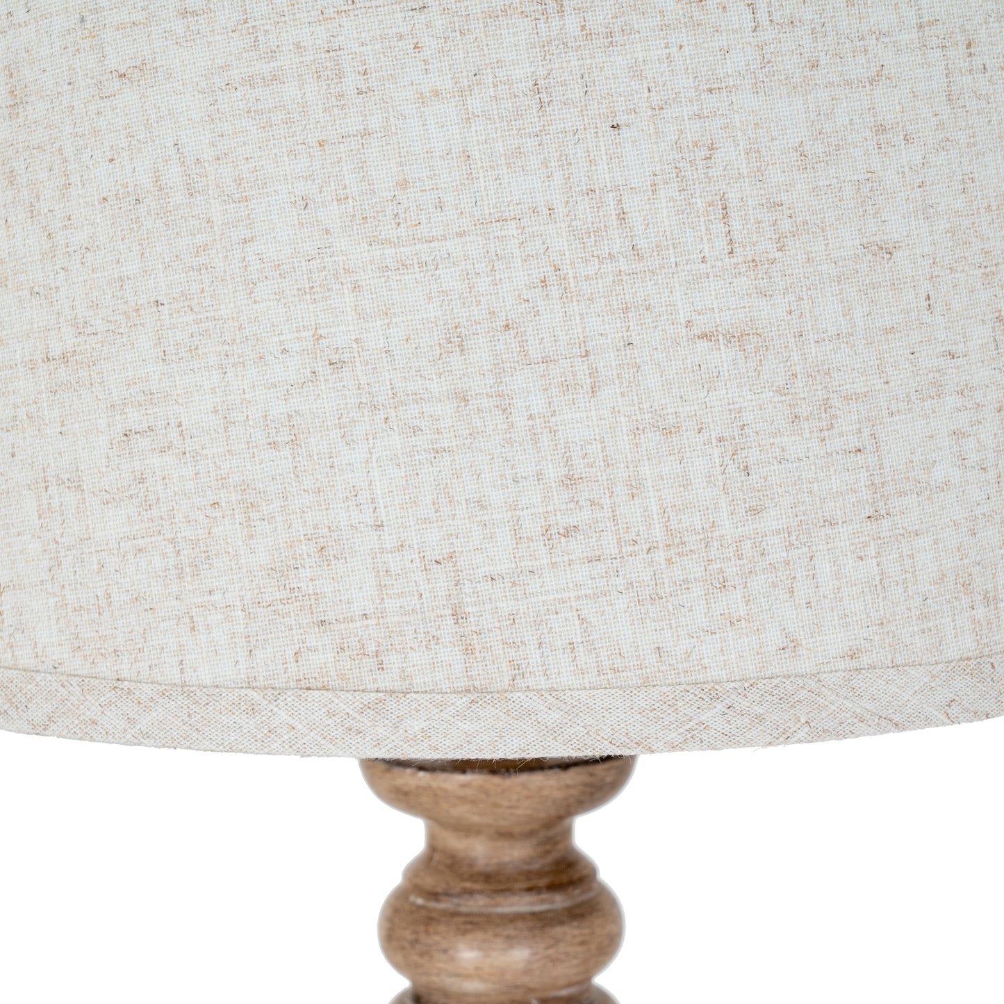 Close-up of a textured lampshade with a wooden base on a white background
