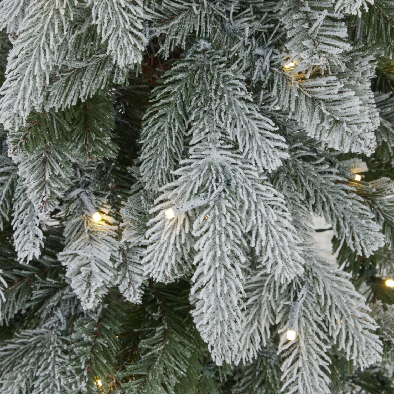 Close-up of a frosted artificial Christmas tree with lights.