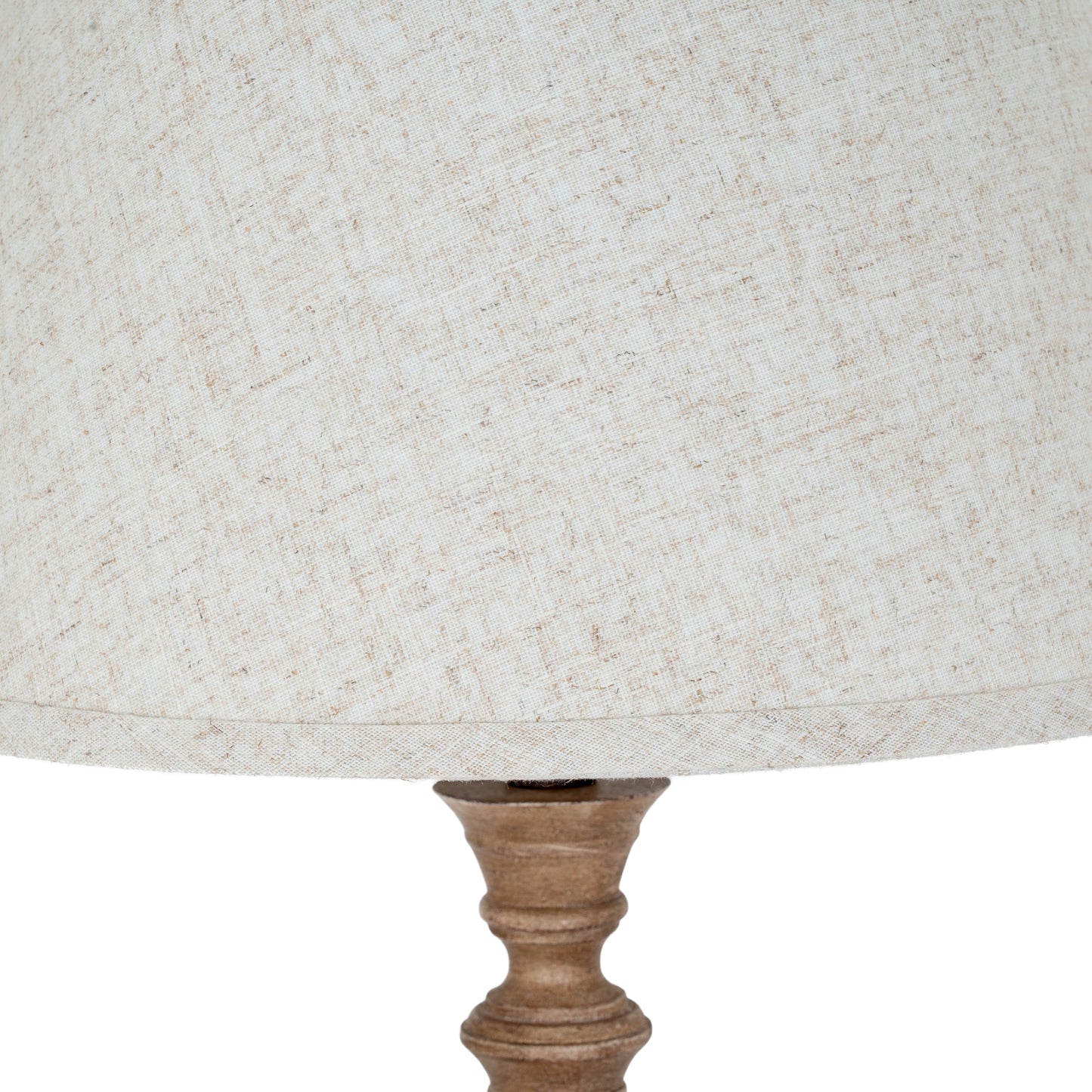 Close-up of a textured lampshade with a wooden base on a white background