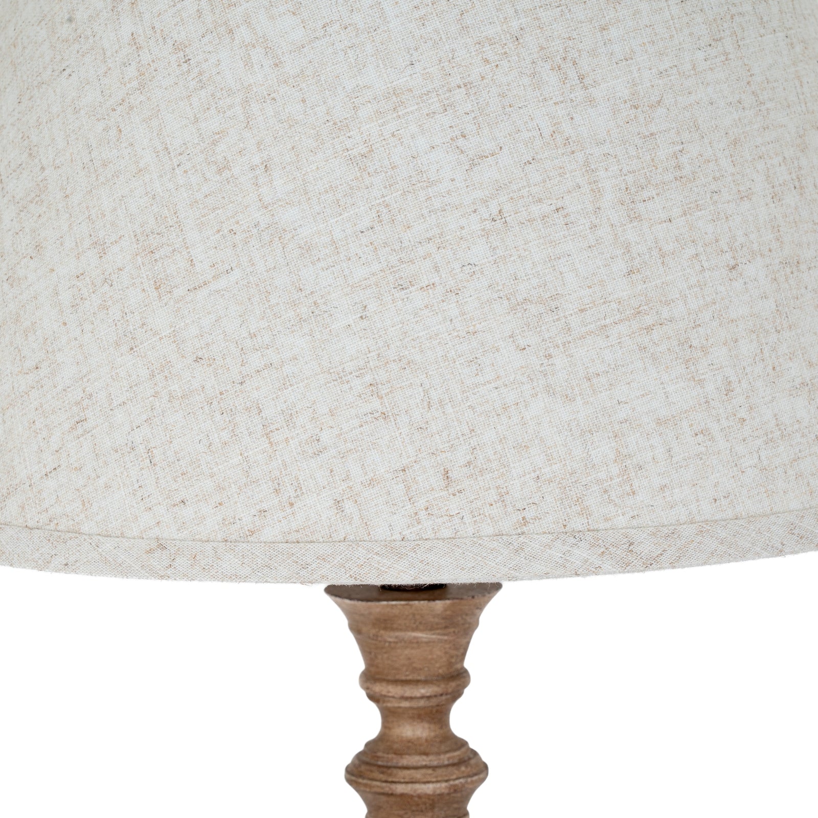 Close-up of a textured lampshade with a wooden base on a white background