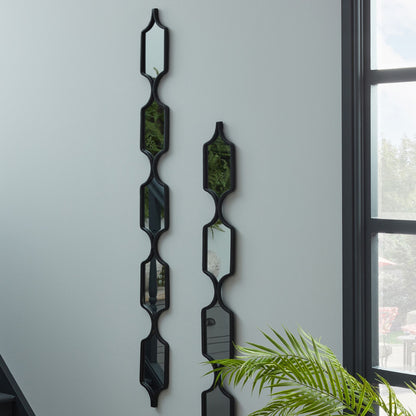 Decorative wall mirrors with geometric design on a light gray wall.