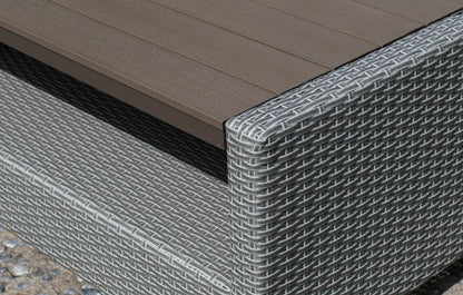 Close-up of a wicker outdoor furniture piece with a brown top.