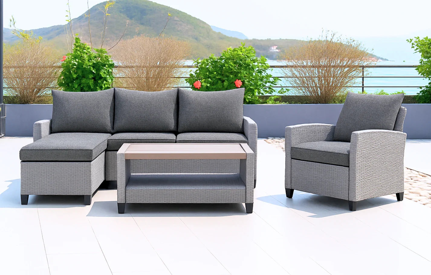 Outdoor patio furniture set with gray cushions on a rooftop with greenery and mountains in the background.