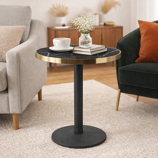 Small round table with black marble top and gold rim in a living room setting.