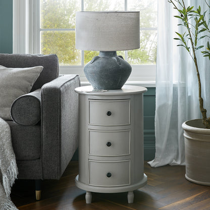 Gray side table with lamp next to a gray sofa in a living room.
