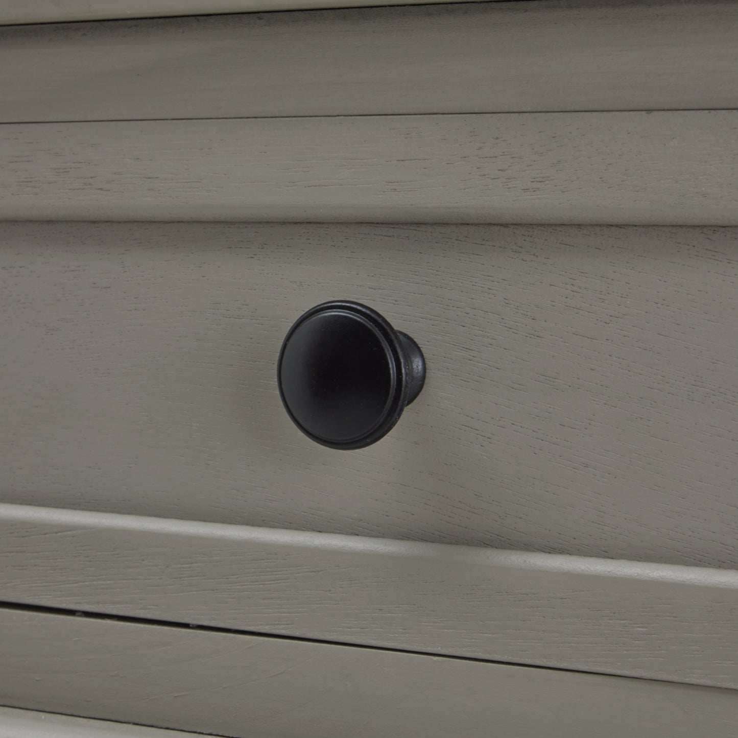 Close-up of a gray drawer with a black knob