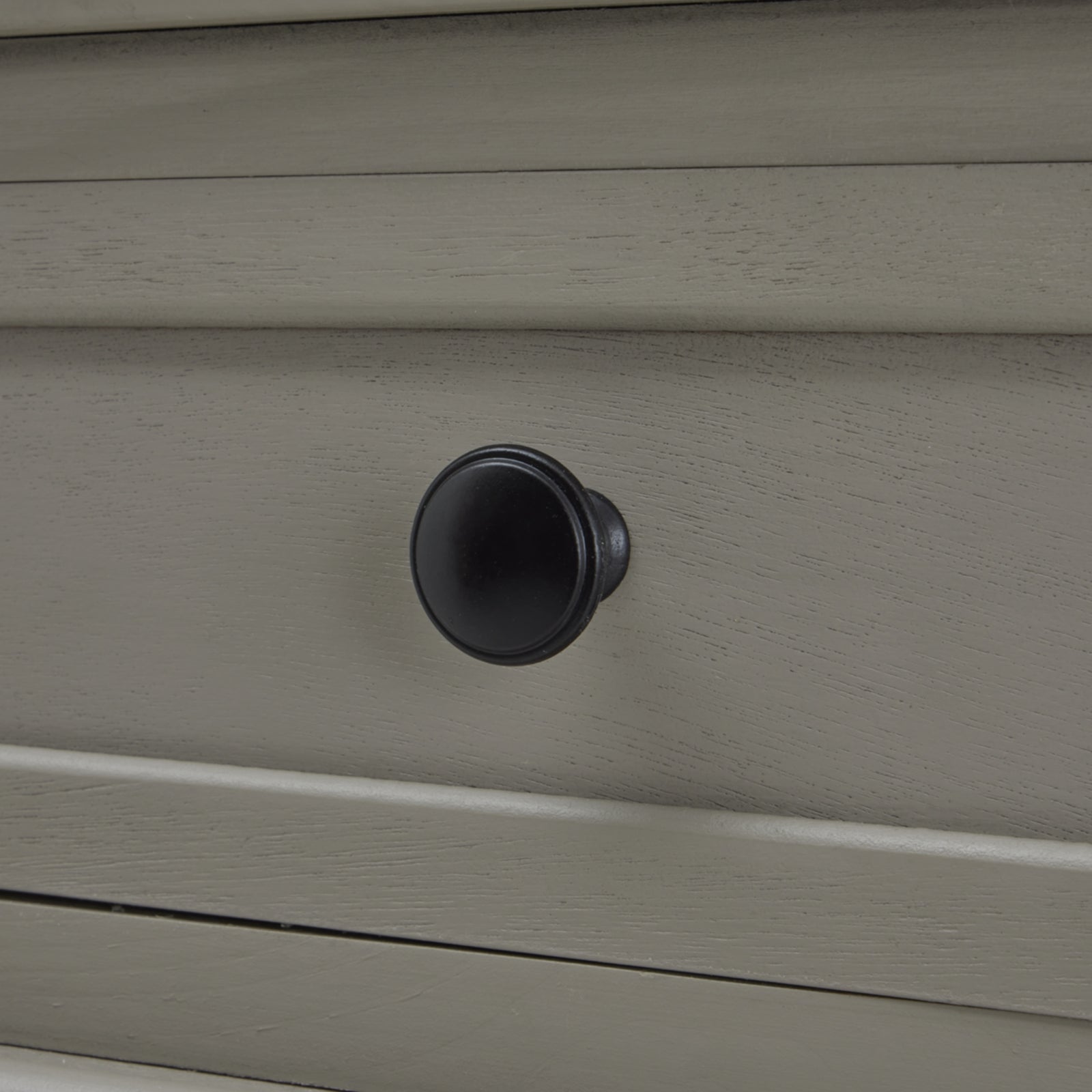 Close-up of a gray drawer with a black knob