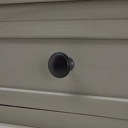 Close-up of a gray drawer with a black knob