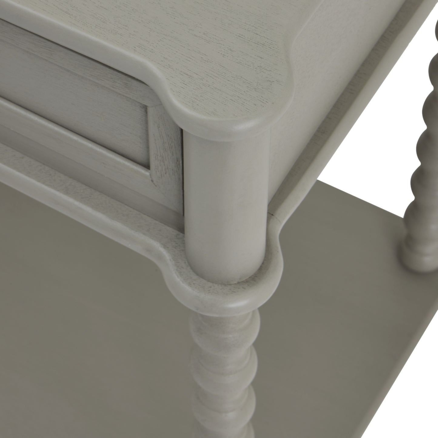 Close-up of a white wooden side table with decorative legs.