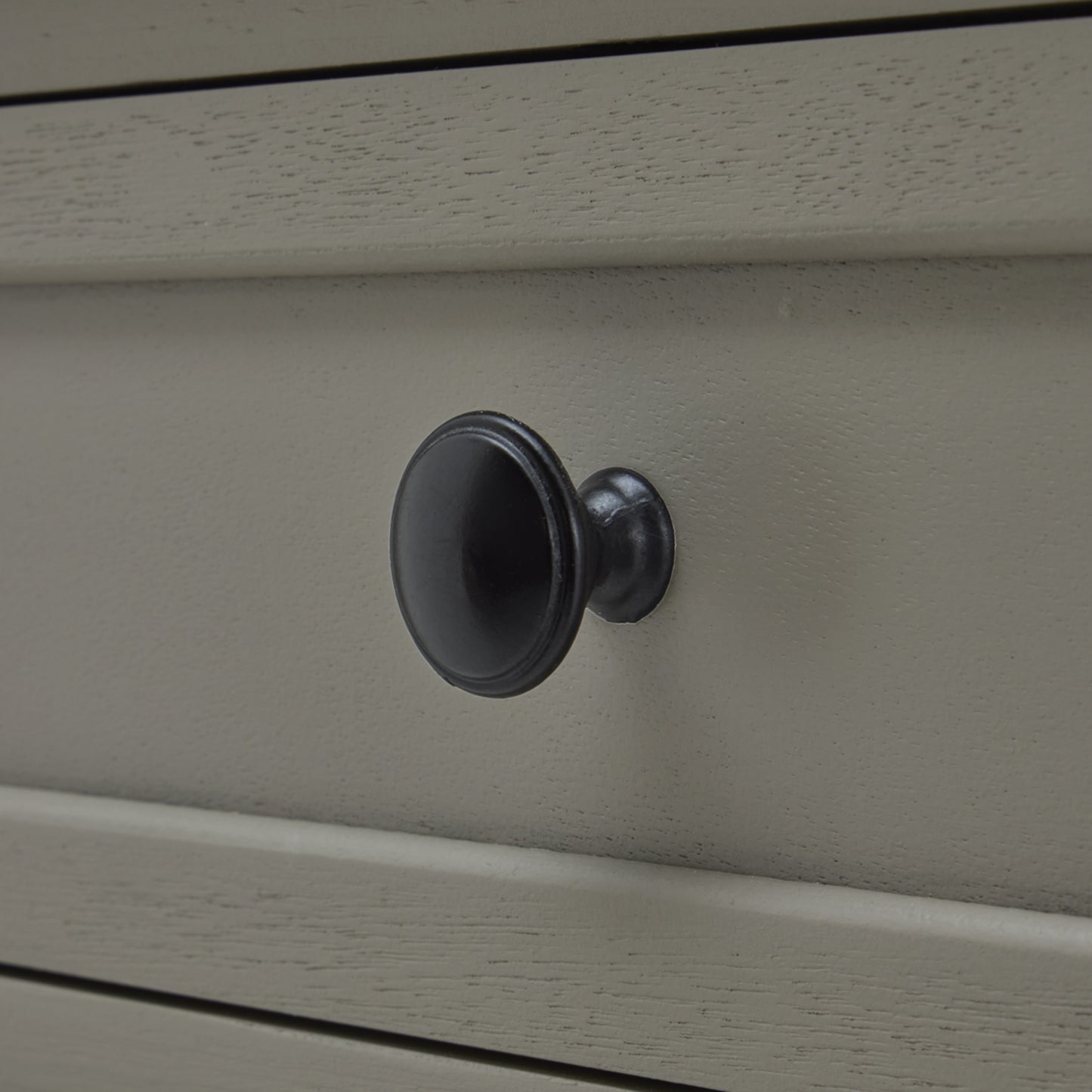 Close-up of a gray cabinet with a black knob