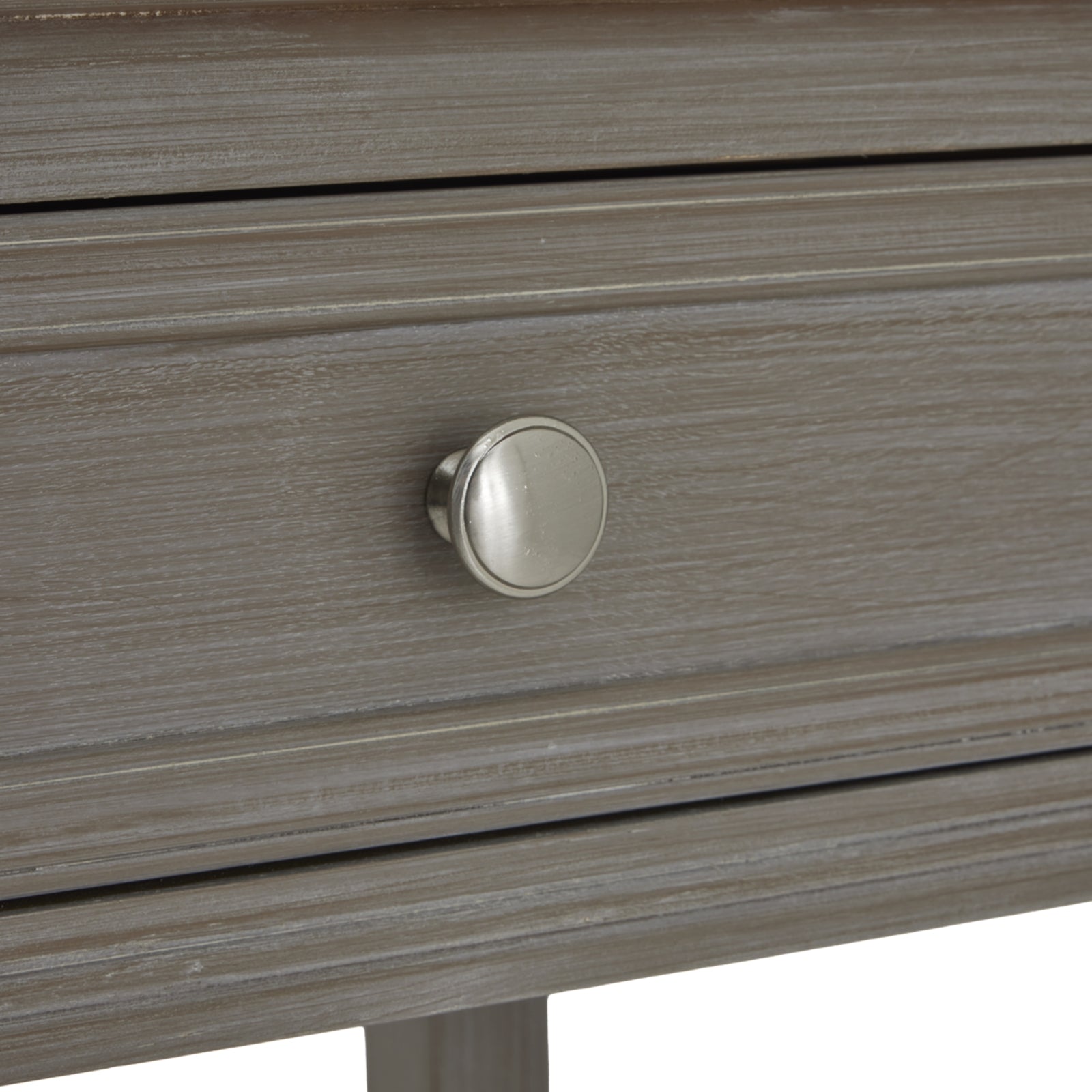 Close-up of a wooden drawer with a metallic knob on a white background