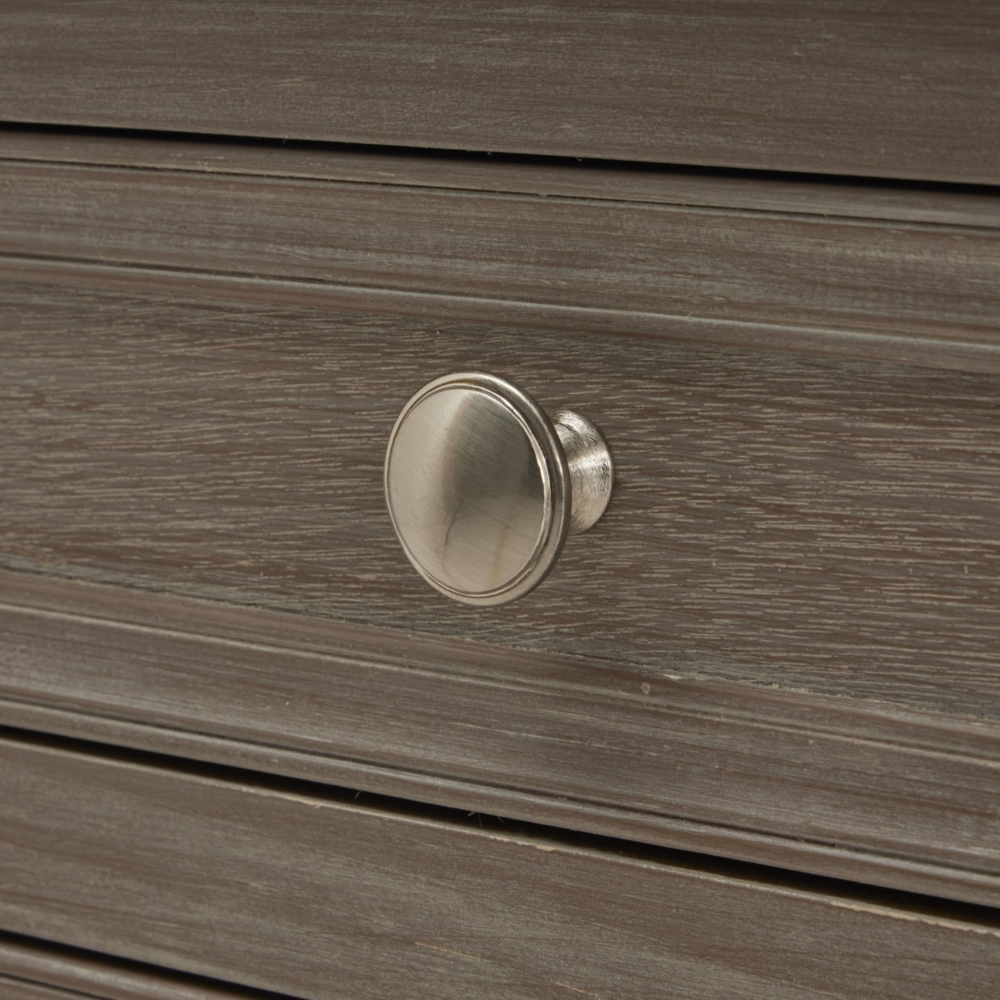 Close-up of a wooden drawer with a silver knob