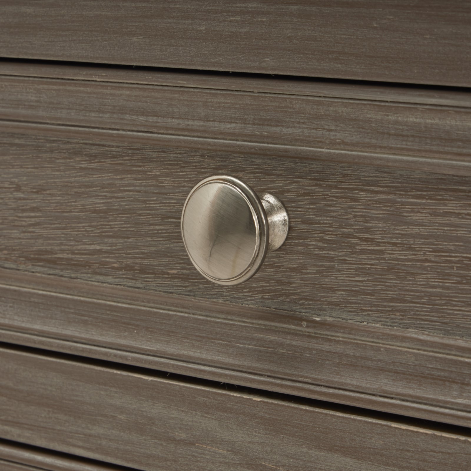 Close-up of a wooden drawer with a silver knob