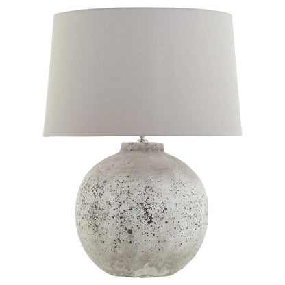 Table lamp with a textured concrete base and a gray fabric shade on a white background