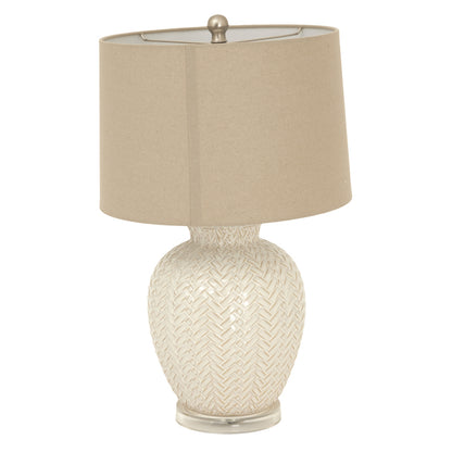 Table lamp with woven design base and beige shade on a white background