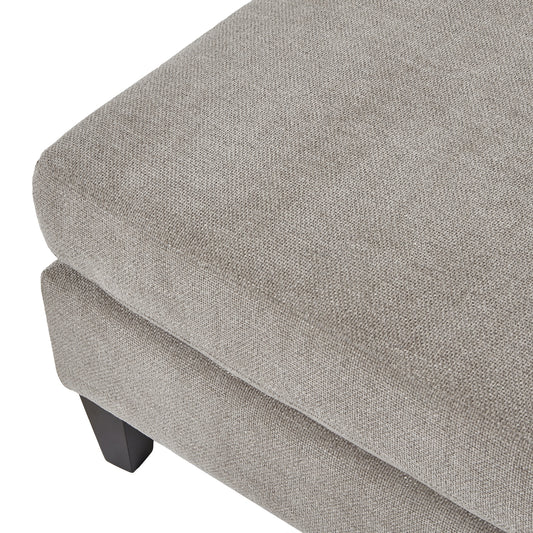 Gray upholstered ottoman with a textured surface on a white background