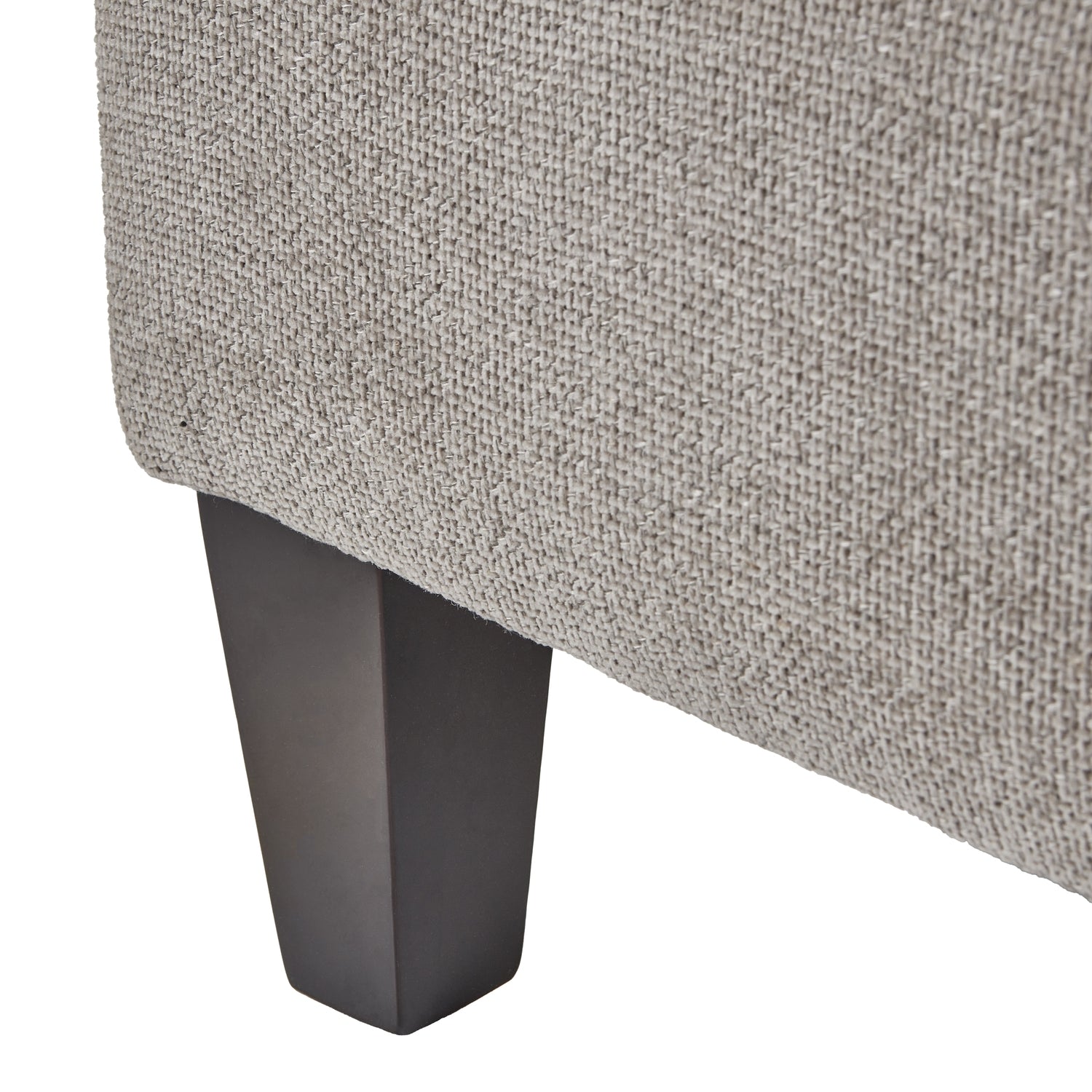 Close-up of a textured gray upholstered chair corner with a dark metal leg on a white background