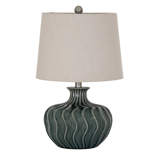 Table lamp with a textured green base and beige lampshade on a white background