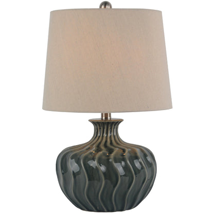 Table lamp with a textured ceramic base and beige lampshade on a white background